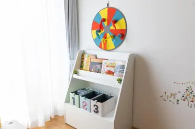 a white book shelf in a room with a clock on the wall at DREAM STAY Urayasu in Tokyo