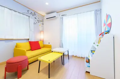 a living room with a yellow couch and a table at DREAM STAY Urayasu in Tokyo