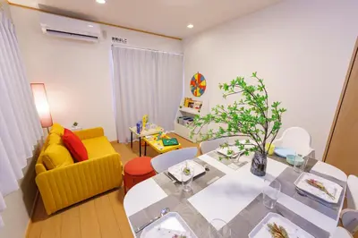 a living room with a dining table and a yellow couch at DREAM STAY Urayasu in Tokyo