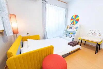 a small bedroom with a yellow bed and a red chair at DREAM STAY Urayasu in Tokyo