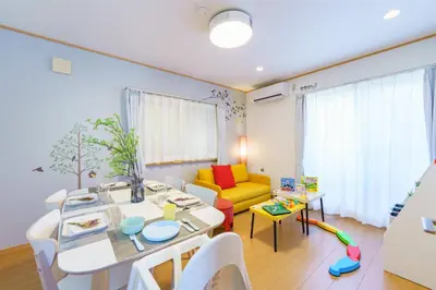 a living room with a table and a yellow couch at DREAM STAY Urayasu in Tokyo