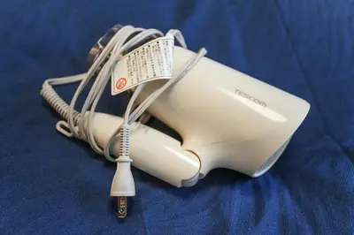 a white hair dryer sitting on a blue sheet at Asakusa 5 Chome One Bedroom KazeNoItsu 101 in Tokyo