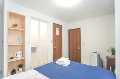 a bedroom with a blue bed and a wooden door at Asakusa 5 Chome One Bedroom KazeNoItsu 101 in Tokyo