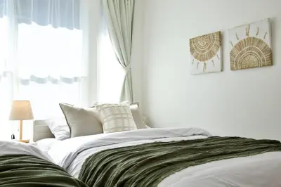 a white bedroom with a bed with a window at Oliver 501 in Tokyo