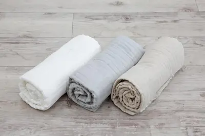 two white towels sitting on a wooden floor at Oliver 502 in Tokyo