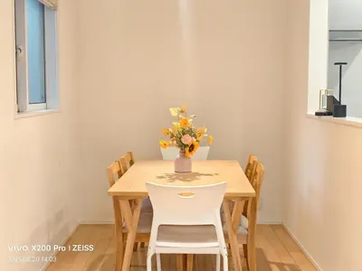 a dining room table with a vase of flowers on it at Ermitage \u6e0b\u8c37\u672c\u753a \u6238\u5efa in Tokyo