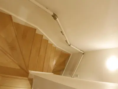 a room with a staircase with wooden floors and a light at Ermitage \u6e0b\u8c37\u672c\u753a \u6238\u5efa in Tokyo