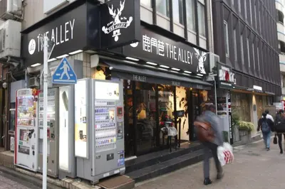 a person walking down a street in front of a store at Ermitage \u6e0b\u8c37\u672c\u753a \u6238\u5efa in Tokyo