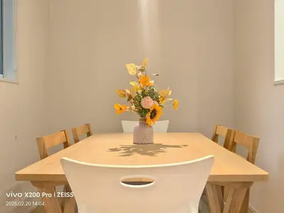 a dining room table with a vase of flowers on it at Ermitage \u6e0b\u8c37\u672c\u753a \u6238\u5efa in Tokyo