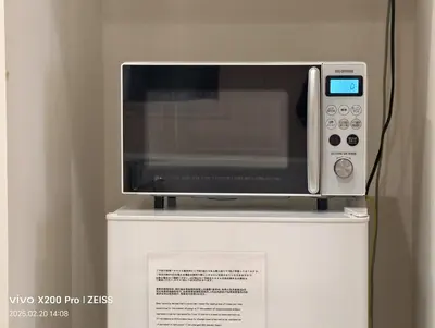 a microwave sitting on top of a refrigerator at Ermitage \u6e0b\u8c37\u672c\u753a \u6238\u5efa in Tokyo