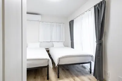 two beds in a room with a mirror at Shibuyahonmachi 1F in Tokyo