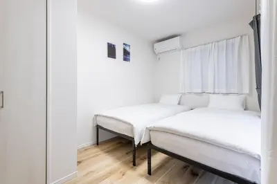 two beds in a room with a mirror at Shibuyahonmachi 1F in Tokyo