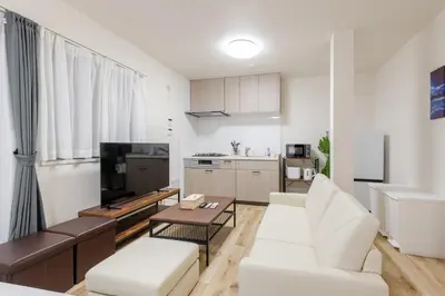 a living room with a white couch and a table at Shibuyahonmachi 1F in Tokyo