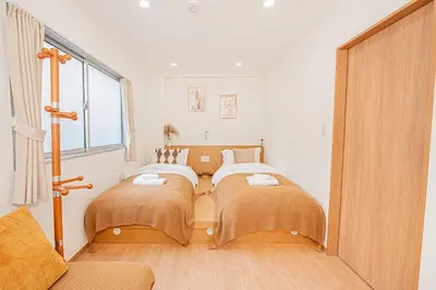 two beds in a room with a window at \u65b0\u5c0f\u5ca9\u99c5\u5f92\u6b696\u5206 50\u5e73 2DK \u6709\u53a8\u623f \u6771\u4eac13\u5206 Skytree15\u5206 in Tokyo