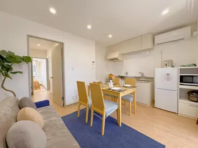 a living room with a couch and a table and a kitchen at \u65b0\u5c0f\u5ca9\u99c5\u5f92\u6b696\u5206 50\u5e73 2DK \u6709\u53a8\u623f \u6771\u4eac13\u5206 Skytree15\u5206 in Tokyo