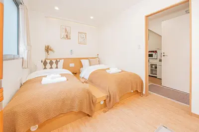 a bedroom with two beds and a mirror at \u65b0\u5c0f\u5ca9\u99c5\u5f92\u6b696\u5206 50\u5e73 2DK \u6709\u53a8\u623f \u6771\u4eac13\u5206 Skytree15\u5206 in Tokyo