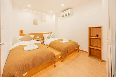 two beds in a small room with two bedsvisor at \u65b0\u5c0f\u5ca9\u99c5\u5f92\u6b696\u5206 50\u5e73 2DK \u6709\u53a8\u623f \u6771\u4eac13\u5206 Skytree15\u5206 in Tokyo