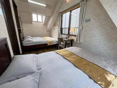a bedroom with two beds and a table with a chair at \u6771\u4eac\u6d45\u8349\u30a4\u30f3501 in Tokyo