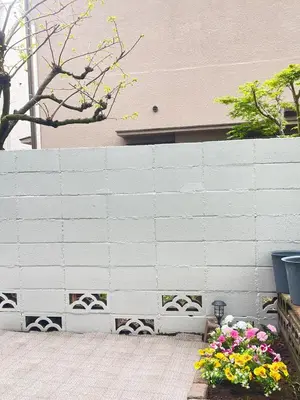 a white brick wall with flowers in a garden at \u5c71\u624b\u7dda\u6c60\u888b\u99c5\u5f92\u6b6915\u5206 \u5927\u585a\u99c5\u5f92\u6b6910\u5206 in Tokyo