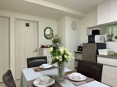 a dining room table with a vase of flowers on it at \u5c71\u624b\u7dda\u6c60\u888b\u99c5\u5f92\u6b6915\u5206 \u5927\u585a\u99c5\u5f92\u6b6910\u5206 in Tokyo