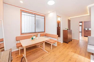 a living room with a wooden table and a window at Asuka Guesthouse \u5bbf-\u98db\u9ce5 in Tokyo