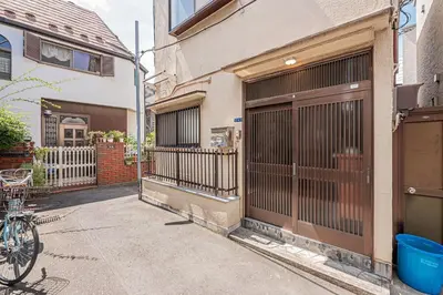 a bike parked next to a building with a garage at Asuka Guesthouse \u5bbf-\u98db\u9ce5 in Tokyo