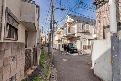 a street with buildings and a car parked on the road at Asuka Guesthouse \u5bbf-\u98db\u9ce5 in Tokyo