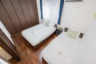 a small room with two beds and a window at Fukuei Stay Premium in Tokyo
