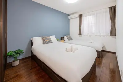two twin beds in a room with a window at Fukuei Stay Premium in Tokyo