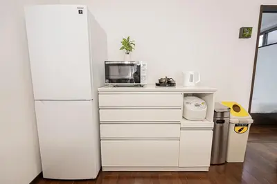 a kitchen with a white refrigerator and a microwave at Fukuei Stay Premium in Tokyo