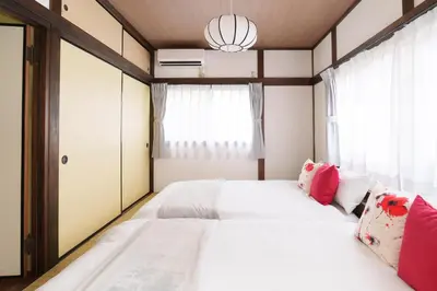 a bedroom with a large white bed with red pillows at The Sakura House - Great access to Ikebukuro, Shinjuku, Shibuya, more - Private 4DK detached house - 1 shower and 2 toilets - Experience Japanese culture in Tokyo