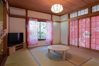 a room with a table and a tv and windows at The Sakura House - Great access to Ikebukuro, Shinjuku, Shibuya, more - Private 4DK detached house - 1 shower and 2 toilets - Experience Japanese culture in Tokyo