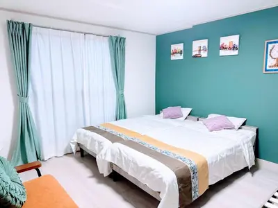a bedroom with a large bed with blue walls at sunflower house in Tokyo