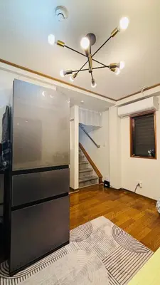 a living room with a ceiling fan and a staircase at sunflower house in Tokyo