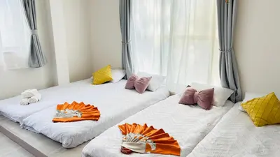 two beds in a room with pillows on them at sunflower house in Tokyo