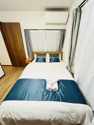a bedroom with a blue and white bed with towels on it at Arashi - Ikebukuro 10 min Shinjuku 20 min in Tokyo
