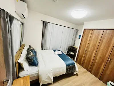 a small bedroom with a bed and a sliding door at Arashi - Ikebukuro 10 min Shinjuku 20 min in Tokyo