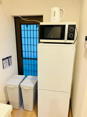 a microwave on top of a refrigerator next to a toilet at Arashi - Ikebukuro 10 min Shinjuku 20 min in Tokyo