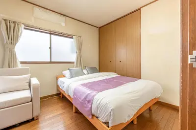 a bedroom with a bed and a chair and a window at \u6c60\u888b1\u4e01\u76ee in Tokyo