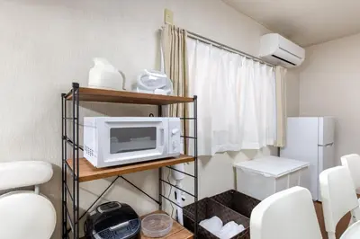 a small kitchen with a microwave on a shelf at \u6c60\u888b1\u4e01\u76ee in Tokyo