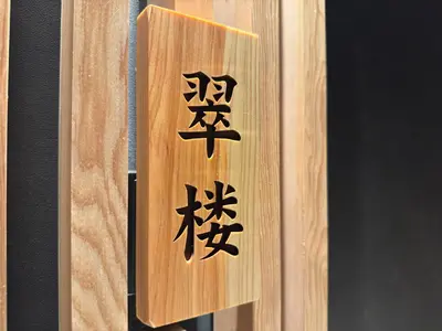 a wooden sign with asian writing on it at suirow \u7fe0\u697c in Tokyo