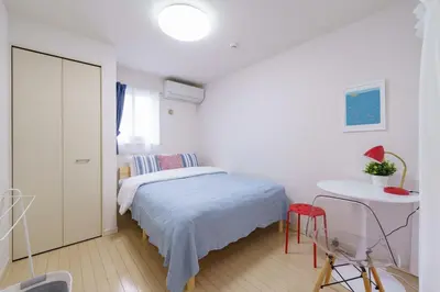 a white bedroom with a bed and a table at -CasaBlue Ikebukuro House- 15-minute walk from Ikebukuro Station in Tokyo
