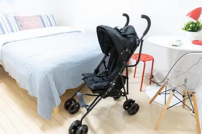 a stroller sitting next to a bed next to a table at -CasaBlue Ikebukuro House- 15-minute walk from Ikebukuro Station in Tokyo