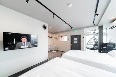 a room with two beds and a tv on the wall at Sunshine Inn 456 - Economic APT in Tokyo Tranquil Block, with Direct Access to Ginza & Akihabara in Tokyo
