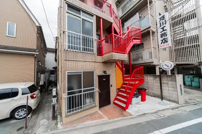 a building with a red staircase on the side of it at Sunshine Inn 456 - Economic APT in Tokyo Tranquil Block, with Direct Access to Ginza & Akihabara in Tokyo