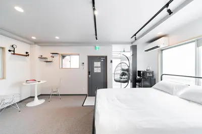 a bedroom with a large white bed and a desk at Sunshine Inn 456 - Economic APT in Tokyo Tranquil Block, with Direct Access to Ginza & Akihabara in Tokyo