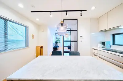 a kitchen with a large white table and chairs at SATELLITE HOTEL Yoyogi Park \u30b5\u30c6\u30e9\u30a4\u30c8\u30db\u30c6\u30eb\u4ee3\u3005\u6728\u516c\u5712 in Tokyo