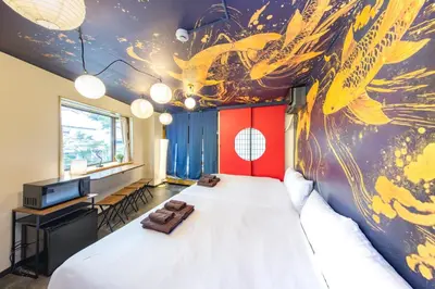 a bedroom with a large bed with a painting on the wall at Luum Stay Shibuya 2 in Tokyo