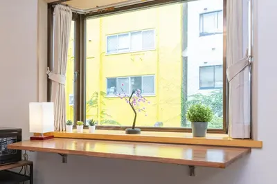 a window with potted plants on a wooden window sill at Luum Stay Shibuya 2 in Tokyo