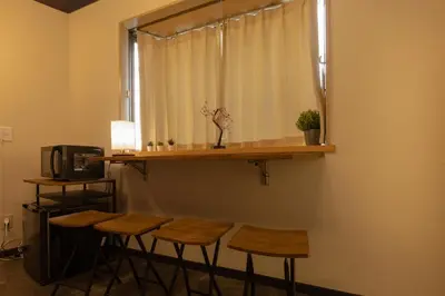 a group of stools sitting under a shelf with a window at Luum Stay Shibuya 2 in Tokyo